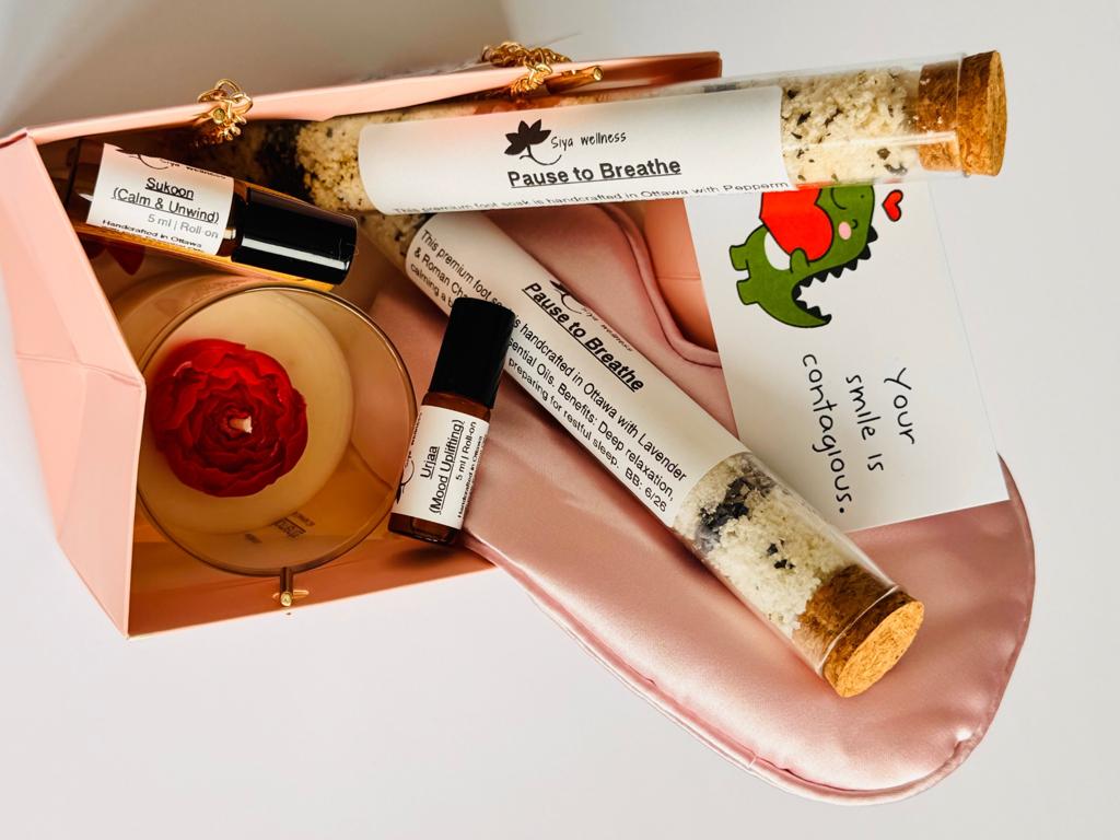 Girls night self care gift box with essential oil roll-ons, botanical foot soak, aromatherapy candle, and silk eye mask for relaxation and wellness